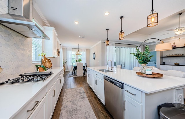 2653 Longleaf Pine Pt, New Port Richey, FL 34655 - kitchen featuring appliances with stainless steel finishes, wall chimney exhaust hood, dark wood-style flooring, ornamental molding, and an island with sink