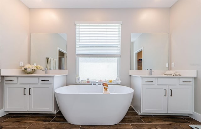 2653 Longleaf Pine Pt, New Port Richey, FL 34655 - full bathroom featuring wood finish floors, a freestanding bath, and two vanities