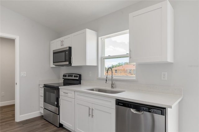 kitchen with dark wood-type flooring, a sink, white cabinetry, and stainless steel appliances