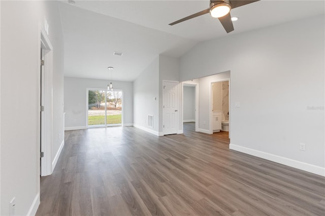 unfurnished living room with visible vents, vaulted ceiling, wood finished floors, and ceiling fan with notable chandelier