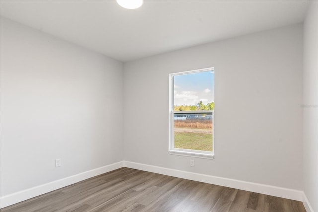 unfurnished room with baseboards and wood finished floors