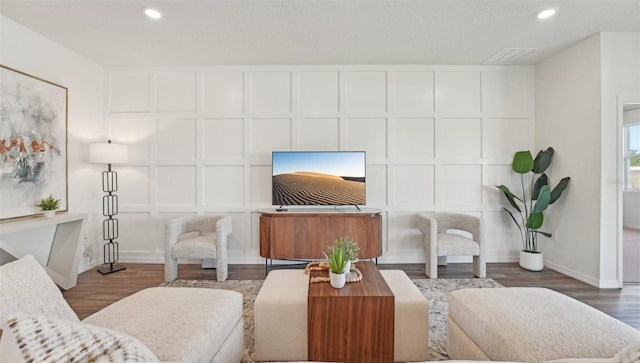 living room with recessed lighting, baseboards, and wood finished floors