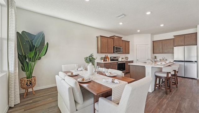 dining space featuring dark wood-style flooring, baseboards, recessed lighting, and visible vents
