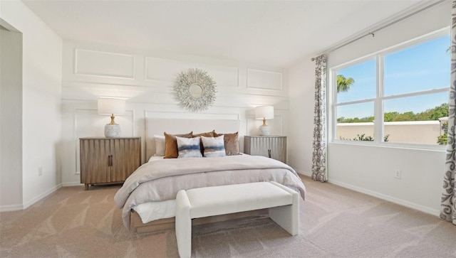 bedroom with baseboards and light colored carpet