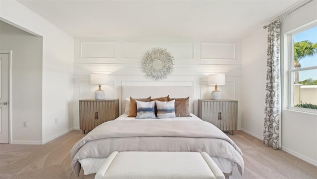 bedroom with baseboards and light colored carpet