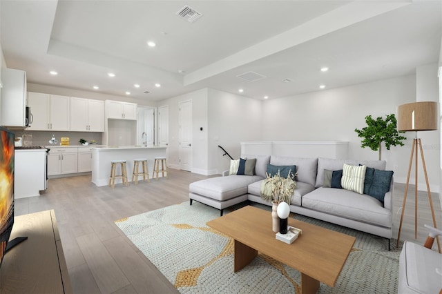 4717 W Mccoy St Unit 2, Tampa, FL 33616 - living area with light wood finished floors, recessed lighting, a raised ceiling, and baseboards