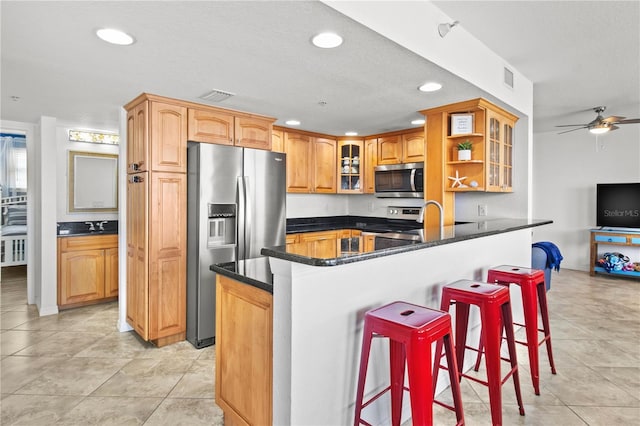445 Hamden Dr Unit 502, Clearwater Beach, FL 33767 - kitchen with appliances with stainless steel finishes, recessed lighting, a kitchen bar, ceiling fan, and glass insert cabinets