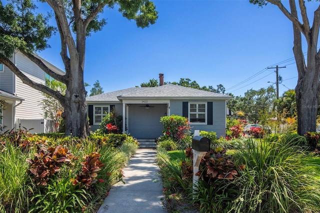 bungalow-style home with a ceiling fan and roof with shingles