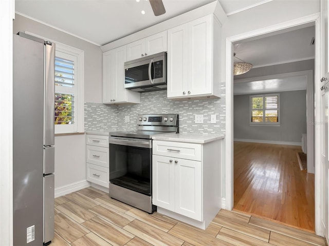 kitchen with light wood-style floors, light countertops, baseboards, and appliances with stainless steel finishes
