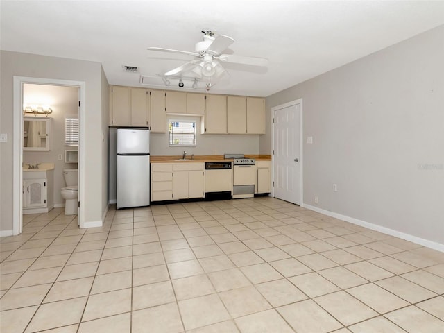 kitchen featuring cream cabinets, a sink, white appliances, a ceiling fan, and visible vents