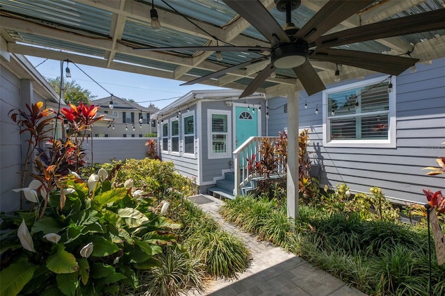 doorway to property with fence and a ceiling fan