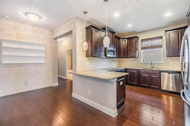 kitchen featuring dark brown cabinetry, visible vents, appliances with stainless steel finishes, a sink, and a peninsula
