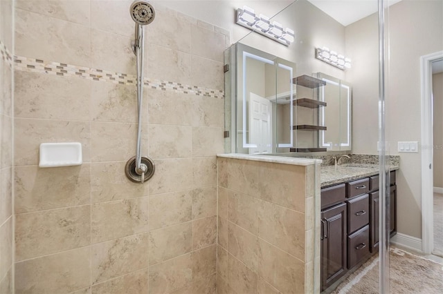 bathroom featuring baseboards, tiled shower, and vanity