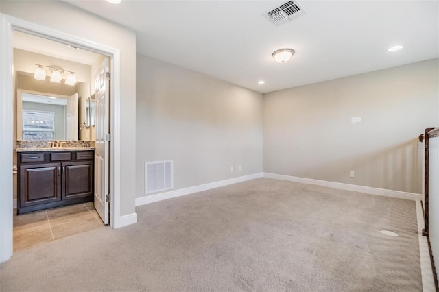 spare room with baseboards, light carpet, recessed lighting, and visible vents