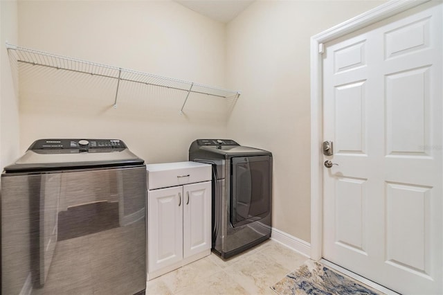 laundry room with baseboards, cabinet space, and independent washer and dryer
