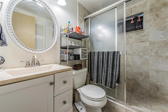 full bathroom with vanity, tile patterned floors, a shower stall, and toilet