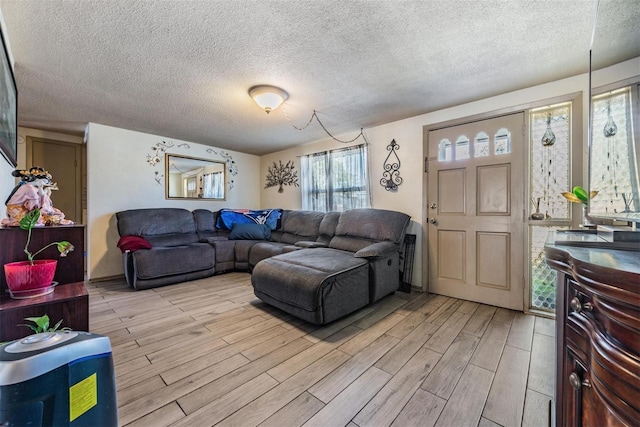 living room featuring light wood-style floors and a textured ceiling