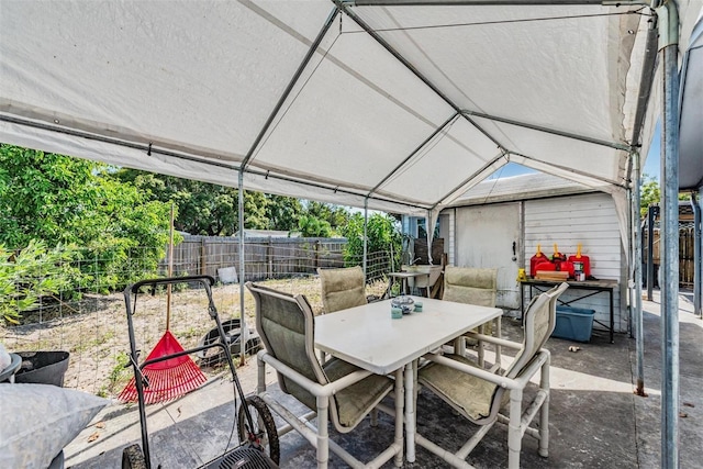 view of patio featuring outdoor dining area and fence