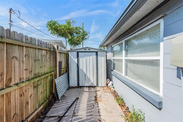 view of patio / terrace featuring a shed, an outbuilding, and fence