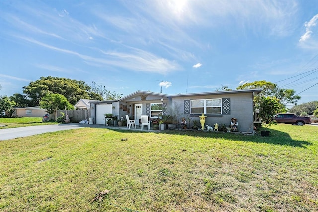 view of front of home featuring a garage, a front lawn, fence, and driveway