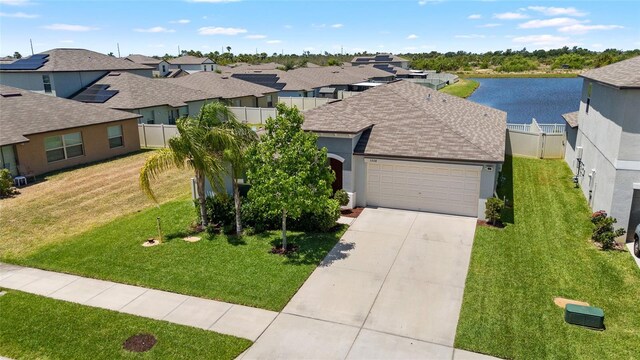 5208 Dandelion St, Apollo Beach, FL 33572 - view of front of home with a garage, stucco siding, a shingled roof, a water view, and driveway