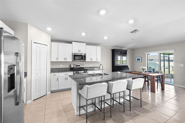 5208 Dandelion St, Apollo Beach, FL 33572 - kitchen with a kitchen bar, visible vents, a center island with sink, a sink, and stainless steel appliances