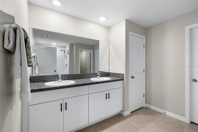 5208 Dandelion St, Apollo Beach, FL 33572 - bathroom with double vanity, baseboards, a sink, and a shower