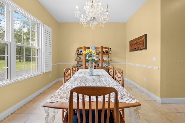dining area featuring light tile patterned floors, a chandelier, and baseboards