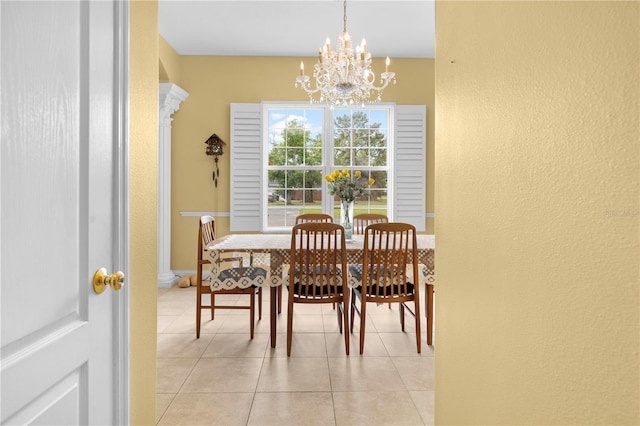 dining area with a textured wall, a chandelier, and light tile patterned floors