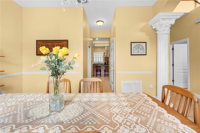 dining room with decorative columns and tile patterned flooring