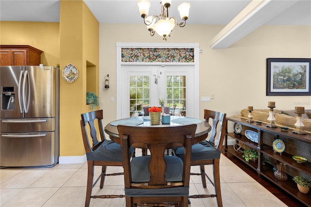 dining space with a chandelier, light tile patterned floors, and baseboards
