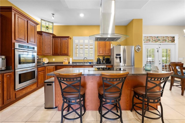 kitchen featuring stainless steel appliances, island range hood, a breakfast bar, a center island, and recessed lighting