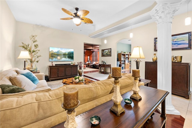 living area with ceiling fan, arched walkways, and ornate columns