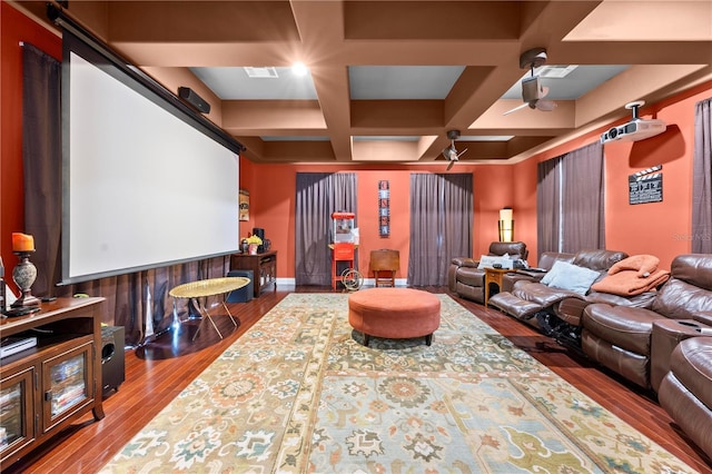 cinema featuring coffered ceiling, wood finished floors, a ceiling fan, and beam ceiling
