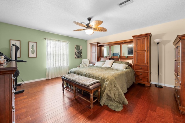 bedroom with baseboards, dark wood-type flooring, ceiling fan, and a textured ceiling