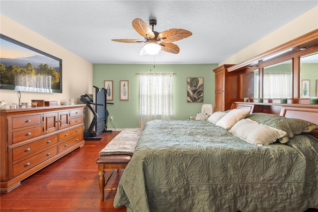 bedroom featuring dark wood finished floors, a textured ceiling, and ceiling fan