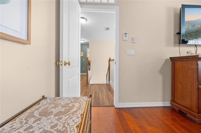 hallway with wood finished floors and baseboards