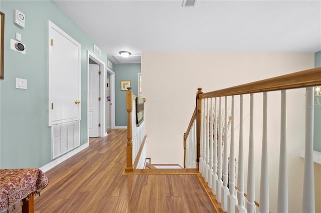 hallway featuring an upstairs landing, light wood-style flooring, and baseboards