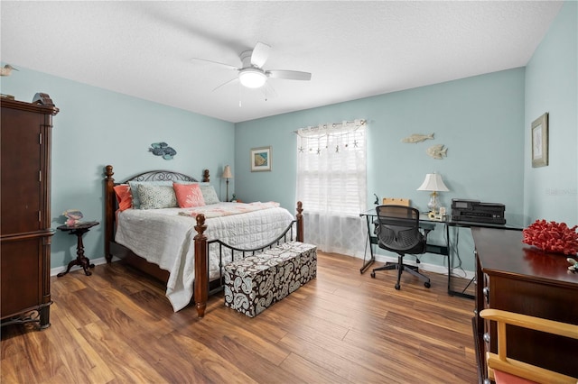 bedroom with wood finished floors, a desk, and a ceiling fan