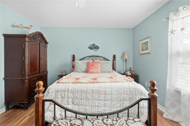 bedroom featuring light wood-style flooring, ceiling fan, and baseboards