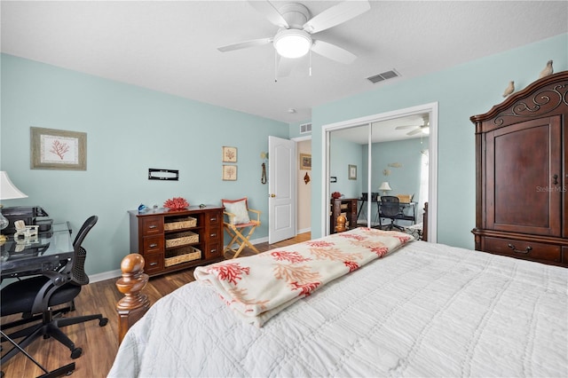bedroom featuring an office area, wood finished floors, baseboards, a closet, and ceiling fan