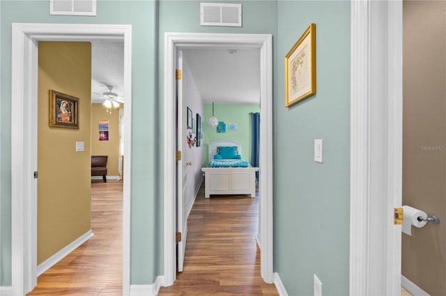 corridor with wood finished floors and baseboards