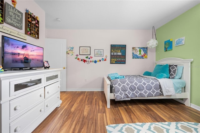 bedroom with wood finished floors and baseboards