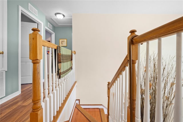 staircase featuring wood finished floors and baseboards