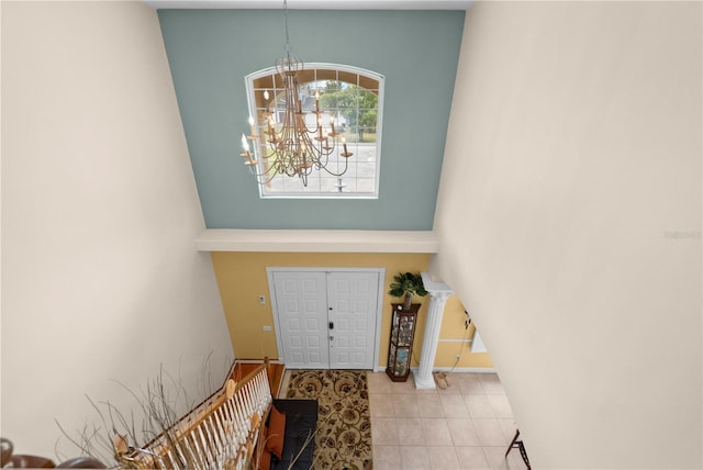 foyer with a chandelier, a high ceiling, and tile patterned flooring