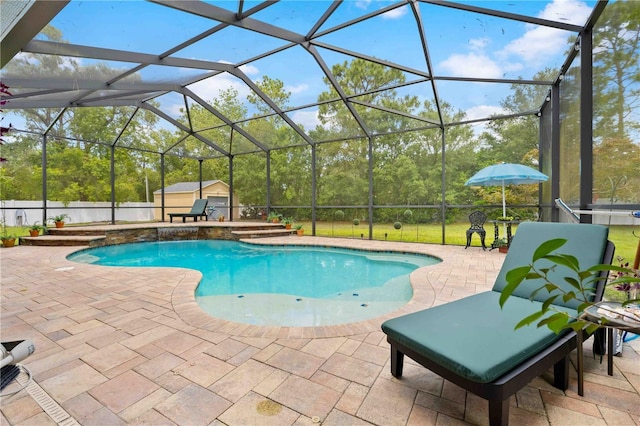 swimming pool featuring a patio area, glass enclosure, an outbuilding, a storage shed, and view of scattered trees