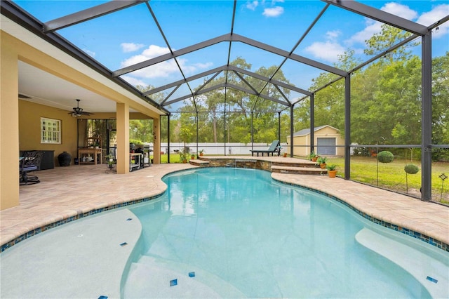 outdoor pool with a patio area, ceiling fan, an outbuilding, and a lanai