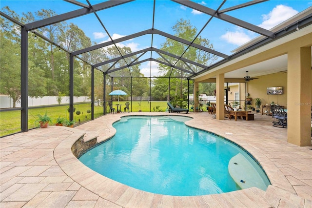 view of pool with a patio area, ceiling fan, and glass enclosure
