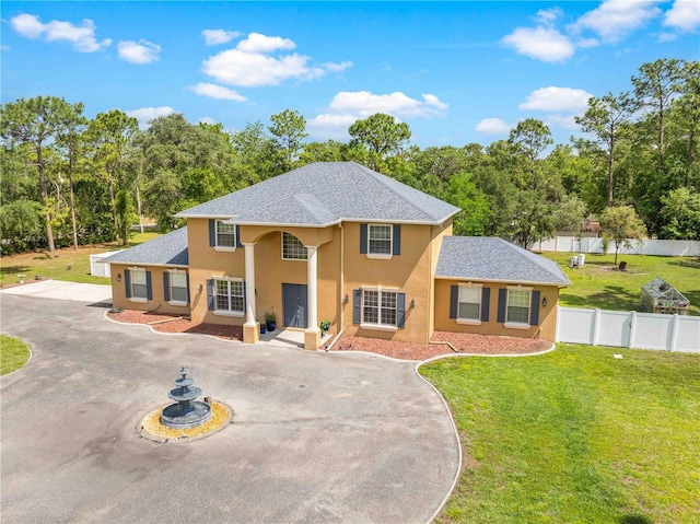 view of front of property featuring stucco siding, curved driveway, and a shingled roof