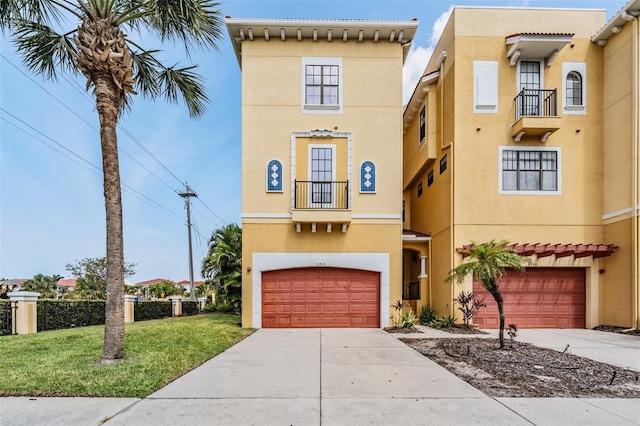 mediterranean / spanish home featuring stucco siding, an attached garage, concrete driveway, and a front yard